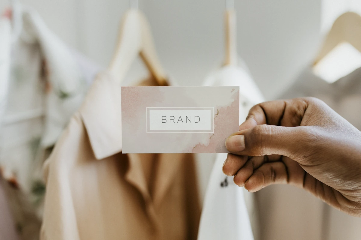 Une personne qui montre une carte avec une marque de vêtements