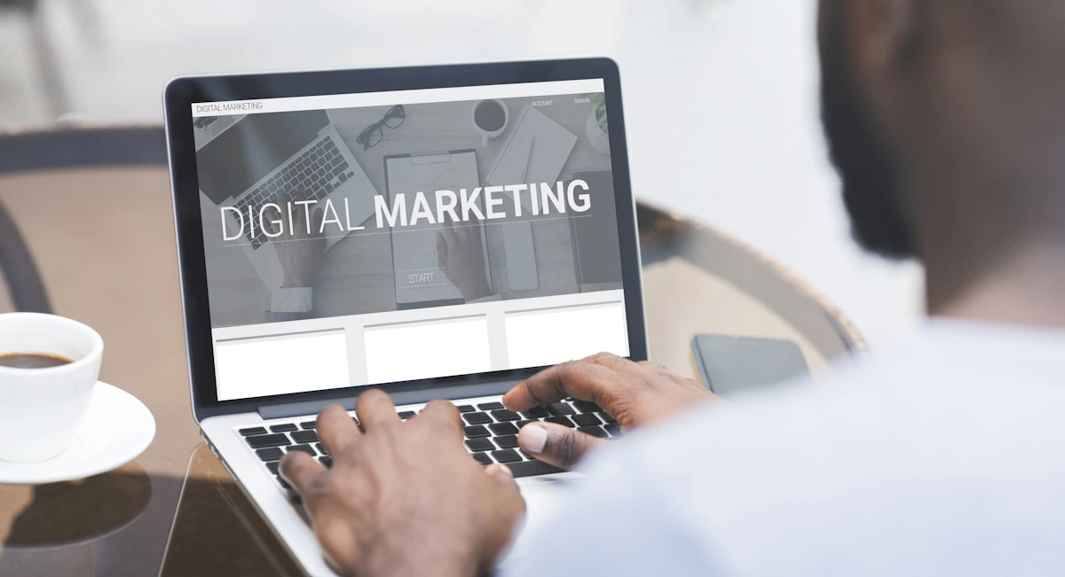 Un homme sur son ordinateur où s'affiche " marketing digital"