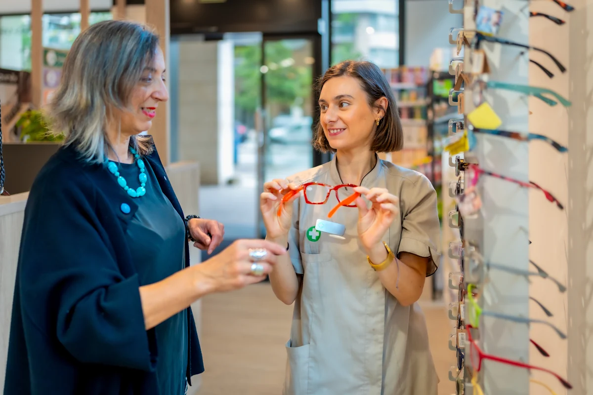 Une opticienne lunetier qui discute avec un client