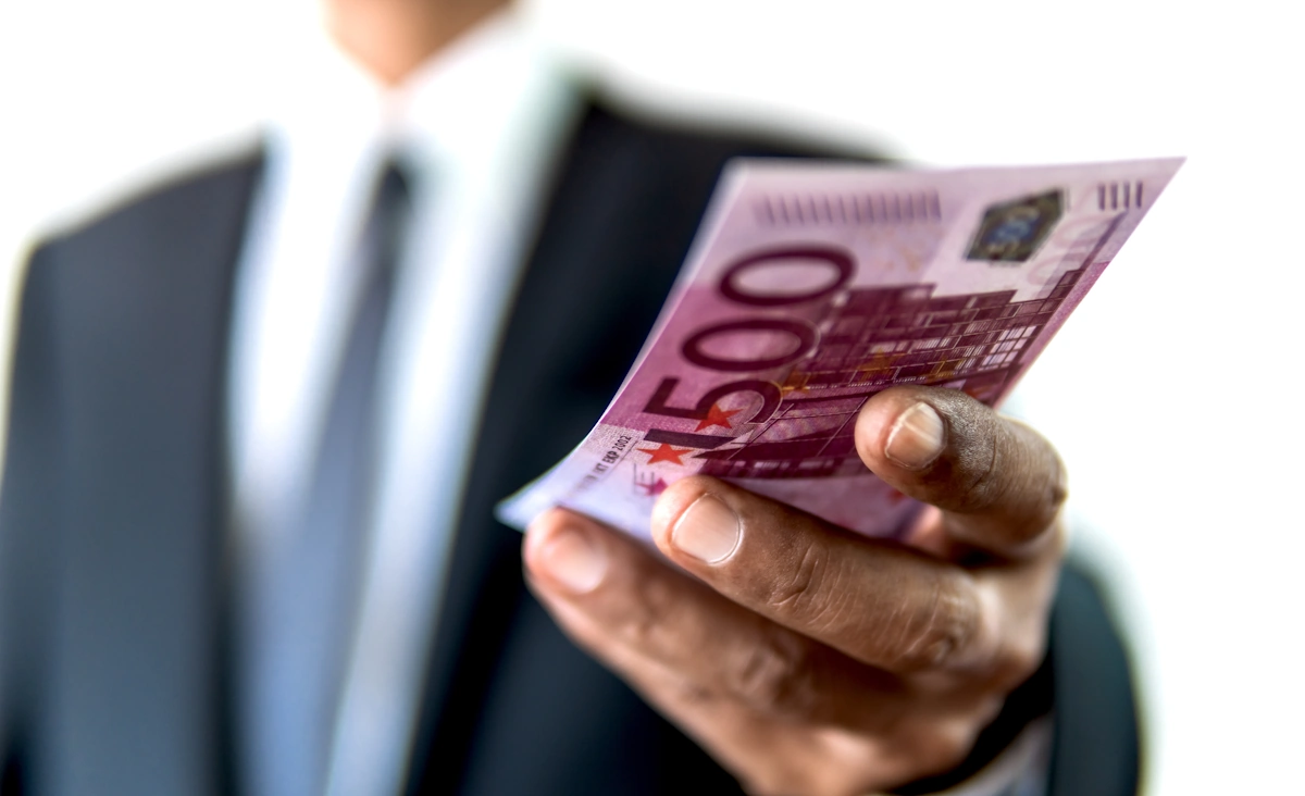 Un homme qui tient des billets d'argent