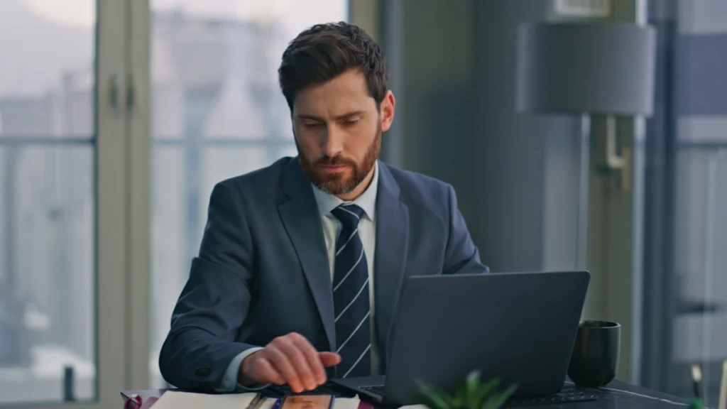 un homme en costume cravate qui travaille sur un ordinateur